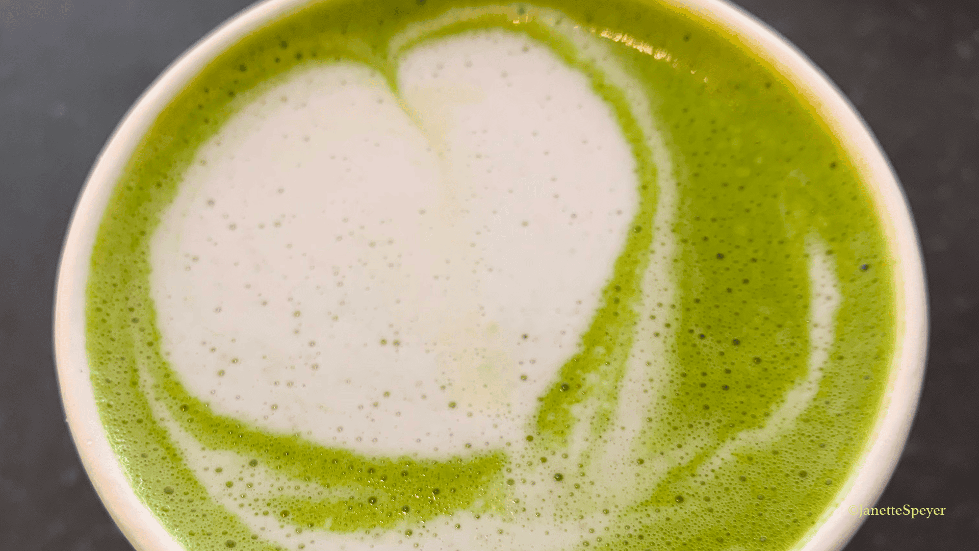 A modern matcha latte complete with foam art.